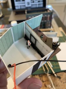 This figure will be brightly backlit to cast a Hitchcock-style silhouette on the other side of the frosted glass.